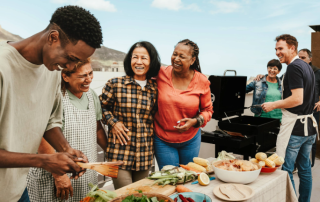 Blended family smiling while barbecuing and prepping a lovely meal.