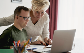 Person with disabilities being helped on the computer