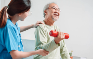Elderly man working out with help of caregiver.