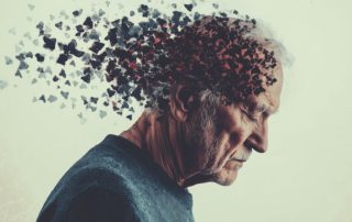 An elderly man looking sad as his brain breaks off into fragments.